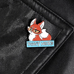Cartoon foxy nerd enamel pin with glasses on black leather background texture