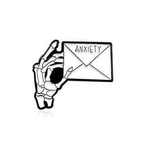 Punk skeleton hand holding anxiety letter enamel pin brooch on white background