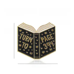 Macro view of book shaped enamel brooch with Turn to Page 394 text and gold stars