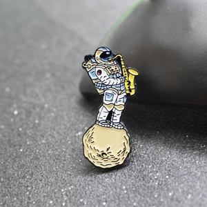 Creative astronaut playing yellow saxophone on moon enamel pin for stylish fashion accessories