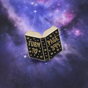 Enamel book brooch featuring Turn to Page 394 text on a starry galaxy background