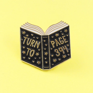 Black book alloy brooch with Turn to Page 394 gold lettering and stars on yellow background