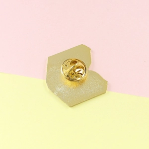 Close-up of golden alloy brooch back with classic butterfly clutch and textured finish