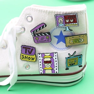 Creative vintage enamel pin set with retro TV and movie icons on canvas sneakers