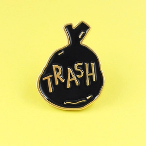 Creative black trash bag enamel pin with gold Trash lettering for eco-friendly fashion
