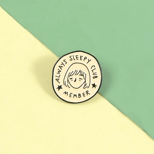 Round enamel pin with ALWAYS SLEEPY CLUB MEMBER text and cute cartoon illustration
