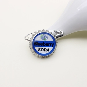 Detail showing the back of the blueberry soda bottle cap brooch with a safety pin attachment