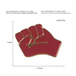 Detail view of red clenched fist enamel pin with 1x1.3 inch dimensions and weight specs