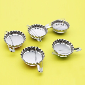 Creative silver bottle cap enamel pins with safety pin backing on yellow background