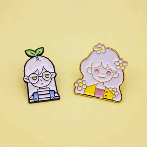 Détail de pins en émail colorés avec des personnages de dessin animé sur fond jaune
