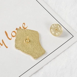 Detail of the golden metal brooch back with textured finish and butterfly clasp
