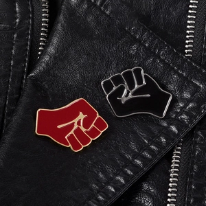 Creative red and black fist enamel pins set displayed on a stylish black leather jacket
