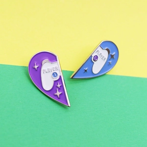 Detail of Player 1 and Player 2 heart-shaped enamel pins for couples with gamepad motif