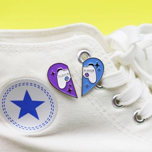 Matching heart-shaped game controller enamel pins with Player 1 and Player 2 text