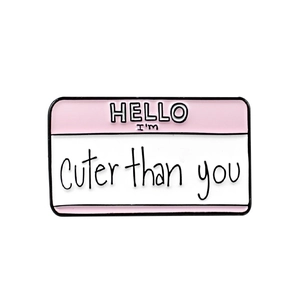 Macro detail of enamel pin with pink donut and handwritten script text design