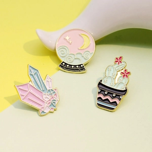 Detail of creative enamel pin set with crystal cluster, moon globe, and flowering cactus