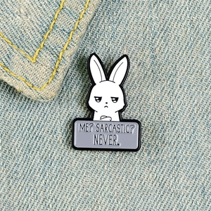 Macro shot of an enamel rabbit pin with sarcastic text on a denim background