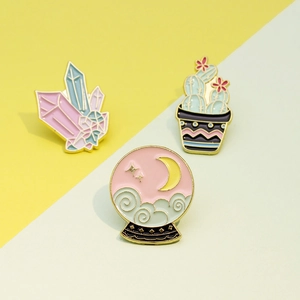 Three-piece enamel pin set featuring pink crystals, cactus, and moon globe designs