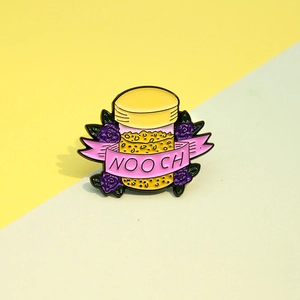 Détail du badge émaillé avec pot de levure nutritionnelle et fleurs violettes