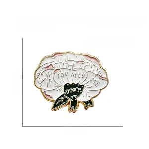 Close-up of white enamel flower brooch with gold trim and IF YOU NEED ME text detail