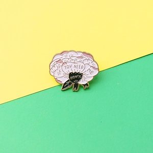 Pink flower enamel brooch with 'IF YOU NEED ME' text and golden metal trim on bright background