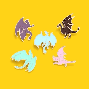 Détail d'un lot de cinq épinglettes en émail en forme de dragon sur fond jaune vif