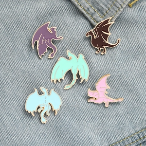 Lot de cinq épinglettes en émail de dragon colorées dans diverses poses de vol