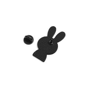 Detail of bunny pin back featuring textured metal surface and black rubber pin clutch