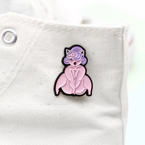 Dettaglio di una spilla creativa in smalto cartoon applicata su una scarpa di tela bianca