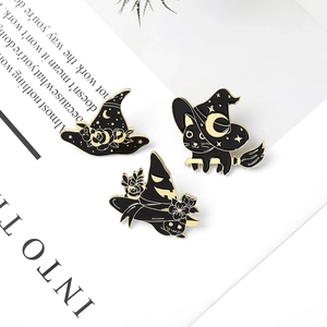 Set de broches en émail chat noir sorcier présentées sur une carte décorative