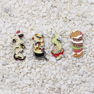 Detailed close-up of colorful enamel food pins featuring ramen, burger, gyoza, and pancakes