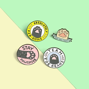 Collection de pin's émaillés patte de chat avec phrases sur fond pastel bicolore