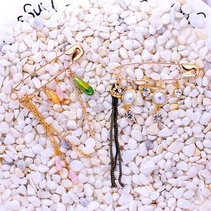 Chic safety pin brooches featuring colorful beads, charms, and multilayered chains