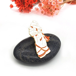 Artistic hands wrapped in red ribbon enamel brooch pin on stone with floral accents