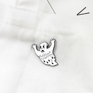 Detailed close-up of ghost enamel pin with Overthink Everything text on white canvas