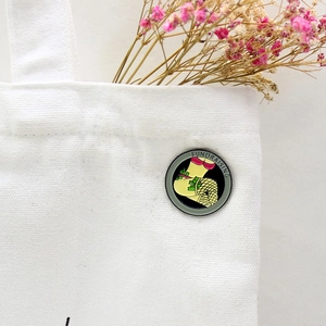 Enameled metal badge featuring fishnet stockings and dollars on a white canvas bag