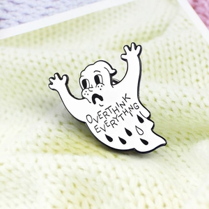 Macro view of cartoon ghost enamel brooch with Overthink Everything text engraving
