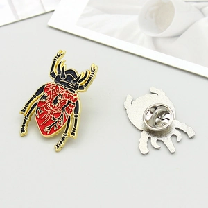 Detail view of beetle brooch with red anatomical heart pattern and butterfly pin clasp