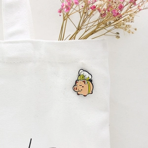 Broche en émail cochon mignon avec pièce de dollar sur la surface d'un sac en toile blanc