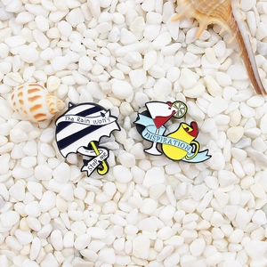 Enamel pin set featuring umbrella and cocktail motifs with ribbons on white stones