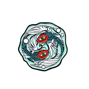 Creative fish enamel pin with yin-yang koi design and wavy edges on a white background