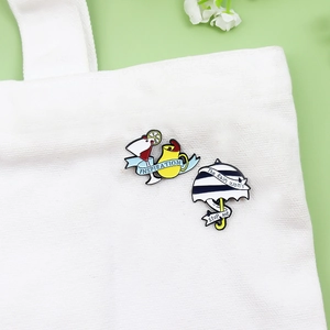 Enamel brooch set with wine glass inspiration ribbon and striped umbrella on canvas bag