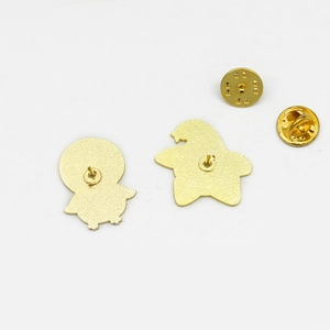 Detail of the golden metal pin back with butterfly clasps on two cartoon-shaped badges