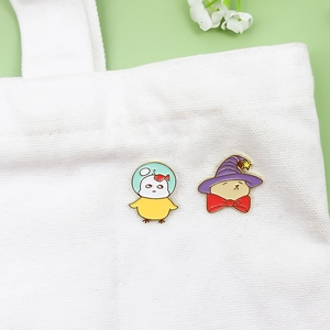Cute cartoon enamel pins featuring a wizard duck and a diving chicken on a canvas bag