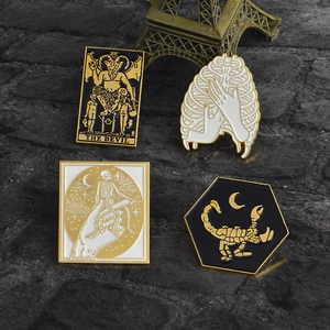 Gothic tarot brooches featuring skeleton hand, devil card, and scorpion on dark stone