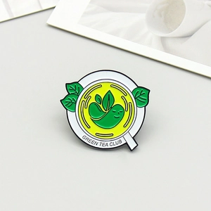 Detailed macro shot of Green Tea Club enamel pin with cute character and vivid green leaves