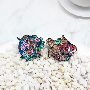 Broches en émail représentant une licorne rose et un poisson rouge sur fond de pierres