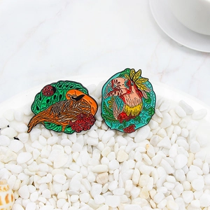 Exquisite enamel toucan and tropical bird brooches with vibrant feather detailing