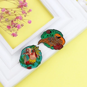 Colorful toucan and bird enamel brooches set with tropical plant and flower motifs