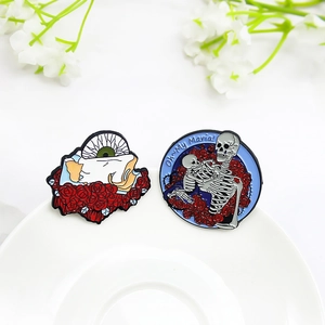 Gothic skull and rose enamel pins set with eye motif on white porcelain display